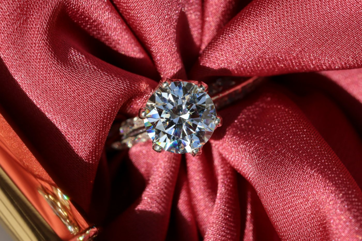 Diamond ring resting on red satin